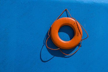 Red life preserver against blue wall - MINF15103