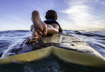 Rear view and close up of a 3 years old surfer on wooden surfboard - CAVF88361