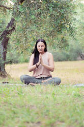 Reife Frau beim Yoga im Park - FMOF01062