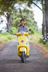 Vietnamesische Frau mit gelbem Motorroller in einer ländlichen Gegend in Vietnam - CAVF88408