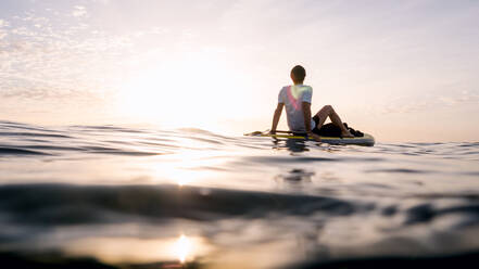 Konzept: Ruhe und Entspannung. Mann sitzt auf Paddel Surf - CAVF88409
