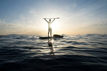 Konzept: Sieg und Glück. Mann auf einem Paddel Surfbrett. In t - CAVF88410
