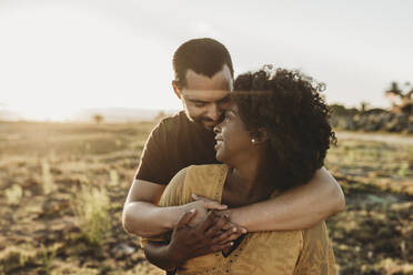 Young married couple embracing pregnancy at beach - CAVF88482