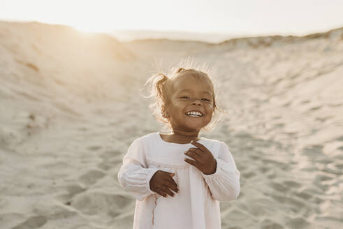Porträt eines bezaubernden jungen Mädchens am Strand bei Sonnenuntergang - CAVF88484