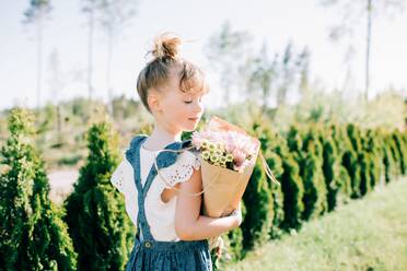 Porträt eines hübschen jungen Mädchens, das einen schönen Blumenstrauß hält - CAVF88493