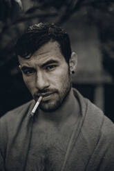 Ein Mann mit einer Zigarette im Mund, Schwarz-Weiß-Foto. - CAVF88520
