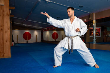 Karate man stand your ground on tatami doing 