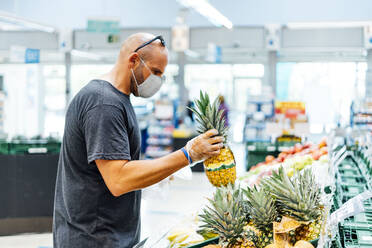 Mann kauft frisches Obst im Supermarkt - CAVF88570