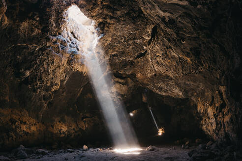 Lichtstrahlen durchdringen die dunkle vulkanische Höhle - CAVF88575