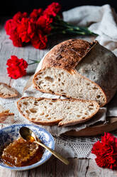 Pieces of tasty fresh bread falling on napkin on table against black background - ADSF11567