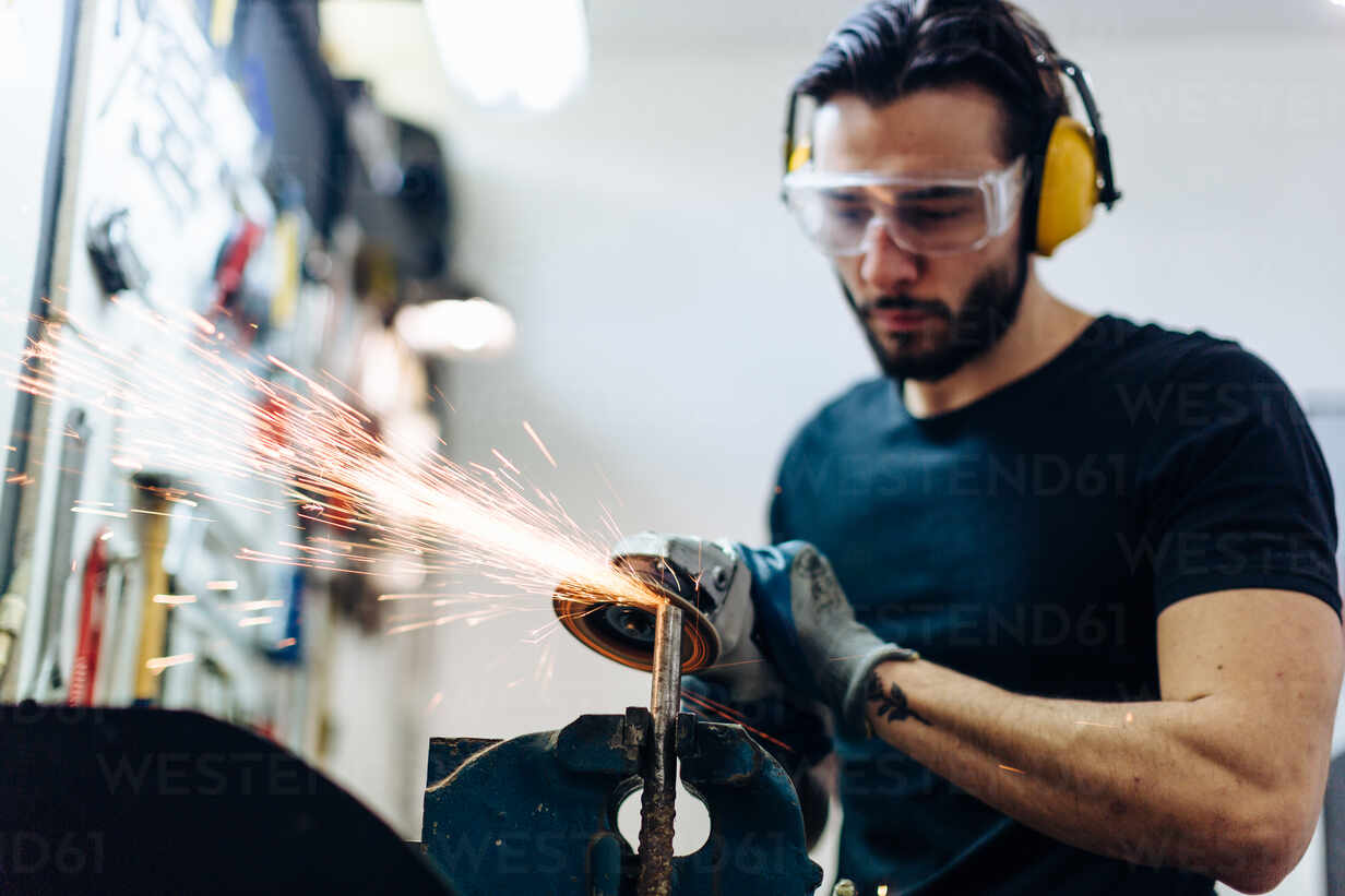 Professional men wearing goggles and construction gloves work in home  workshop with angle grinder. Sanding metal makes sparks, closeup 7641872  Stock Video at Vecteezy