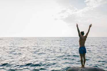 Man standing on rock in sea - CUF56214