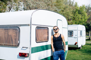 Man leaning against caravan - CUF56228