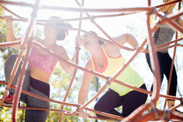 Friends rope climbing in park - CUF56240