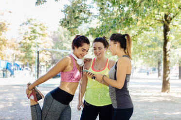 Freunde beim Sport und beim Telefonieren im Park - CUF56278