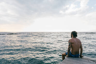 Mann sitzt am Rande des Meeres - CUF56282