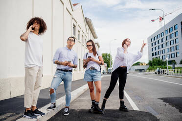 Mixed race group of friends hanging out together in town. - CUF56296