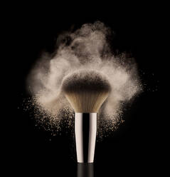 Close up of cosmetic powder brush on black background. - ISF24239