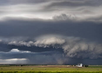 Dark and light wall clouds spin below a tornado super-cell kicking up dust into the updraft base. - ISF24243