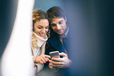Couple using smartphone inside train - CUF56365