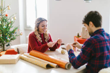 Couple preparing Christmas decorations at home - CUF56380