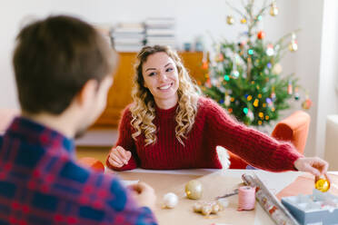 Ehepaar bereitet Weihnachtsdekoration zu Hause vor - CUF56381