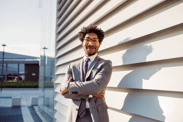 Portrait of businessman wearing glasses and grey suit, smiling at camera. - CUF56435