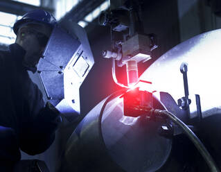 Man wearing welding mask working in a steel factory. - CUF56469