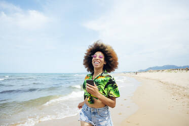 Happy young woman running at the beach - JCMF01159