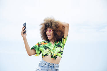 Junge glückliche Frau nimmt Selfie am Strand - JCMF01168