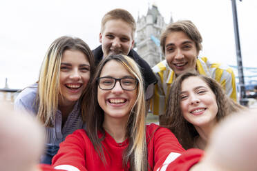 Fröhliche männliche und weibliche Freunde nehmen Selfie in der Stadt - WPEF03275