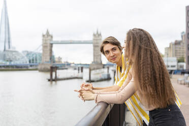 Lächelnder Freund und Freundin lehnen sich an ein Geländer in der Stadt, London, UK - WPEF03286