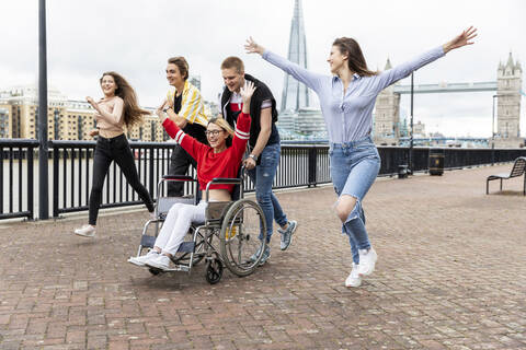 Sorglose Männer und Frauen mit behinderter Freundin verbringen ihre Freizeit in der Stadt, London, UK, lizenzfreies Stockfoto