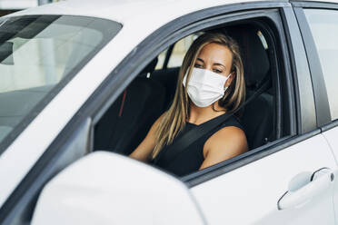 Frau im Auto mit Schutzmaske - MPPF01055
