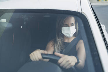 Frau im Auto mit Schutzmaske - MPPF01056