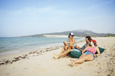 Männliche und weibliche Freunde entspannen sich im Urlaub am Strand, Tarifa, Spanien - OCMF01651