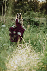 Beautiful woman walking on grass in forest - GMLF00448