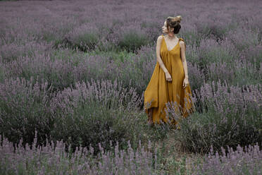 Woman standing in lavender field - GMLF00479