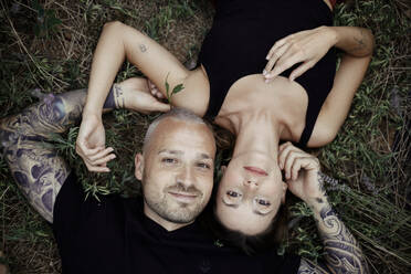 Lächelndes Paar auf Lavendelfeld liegend - GMLF00489