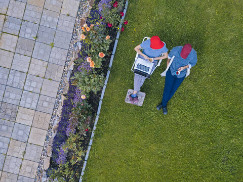 Luftaufnahme eines im Garten sitzenden Paares, lizenzfreies Stockfoto