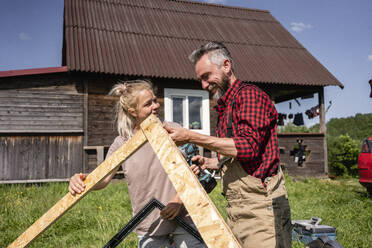 Zimmermann und Frau arbeiten zusammen, um an einem sonnigen Tag ein Haus für Kinder zu bauen - VPIF02827