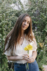 Young woman holding yellow flowers in springtime - RDGF00066