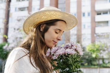 Schöne Frau riecht Strauß frischer rosa Blumen im Frühling - RDGF00070