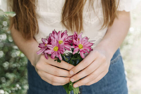 Frau hält frische rosa Blumen - RDGF00073