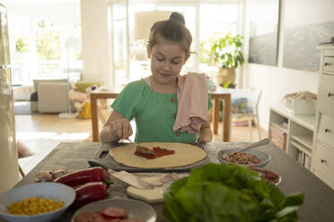 Süßes Mädchen bereitet Pizza über Kücheninsel vor - JOSEF01515