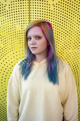 Porträt einer jungen Frau mit gefärbtem Haar vor einer gelben Wand - VPIF02855