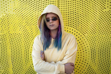 Porträt einer jungen Frau mit gefärbtem Haar vor einer gelben Wand - VPIF02858