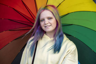 Porträt einer jungen Frau mit gefärbtem Haar unter einem Regenschirm - VPIF02889