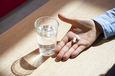 Hand with pills and water glass - AFVF06979