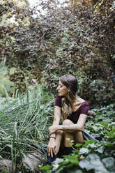 Junge Frau sitzt im Park - DCRF00618